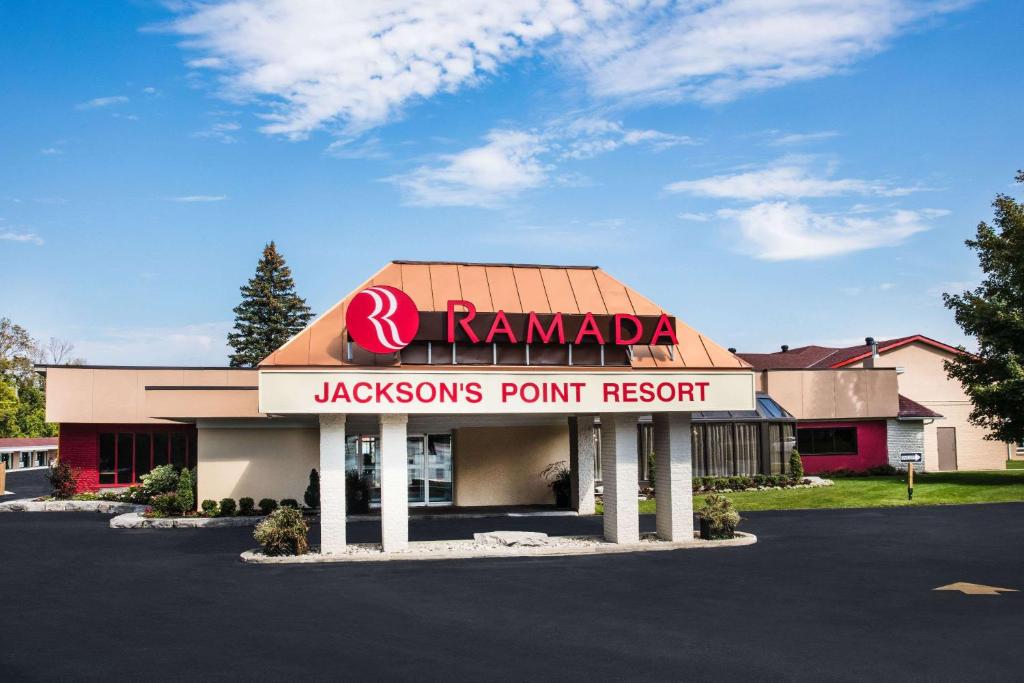 a sign for a karmaeyesons point resort in a parking lot at Ramada by Wyndham Jackson's Point in Georgina
