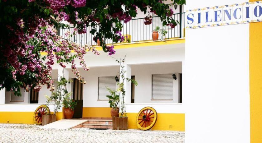żółto-biały budynek z kwiatami w obiekcie Costa Brava Alojamento w mieście Benedita