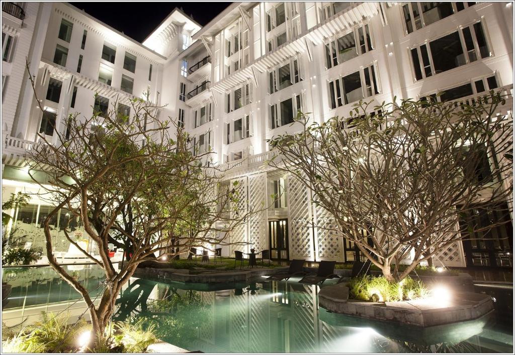 曼谷的住宿－Hua Chang Heritage Hotel，一座大型建筑,前面设有一个游泳池