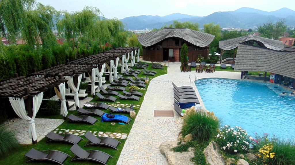 a group of lounge chairs next to a swimming pool at Castel Transilvania in Baia Mare