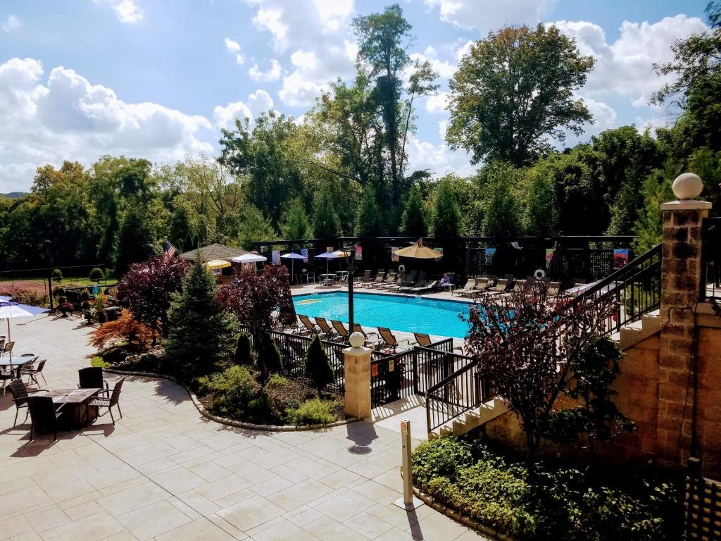 una piscina con mesas y sillas en un complejo en New Hope Inn & Suites, en New Hope