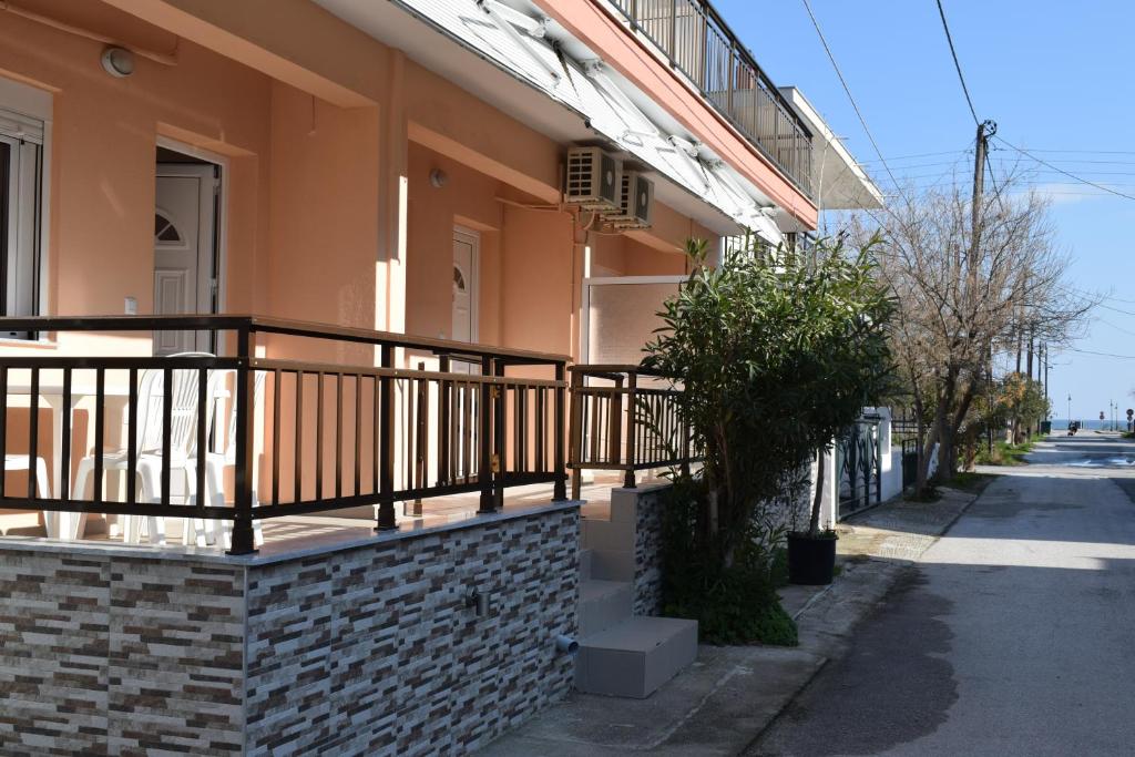 a building with a balcony on a street at Lafazanis rooms in Nea Vrasna