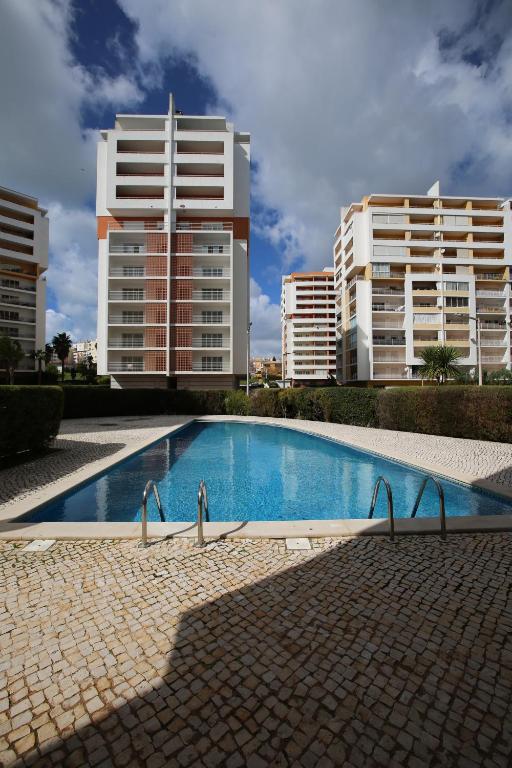 a swimming pool in front of two tall buildings at Chen 1 in Portimão