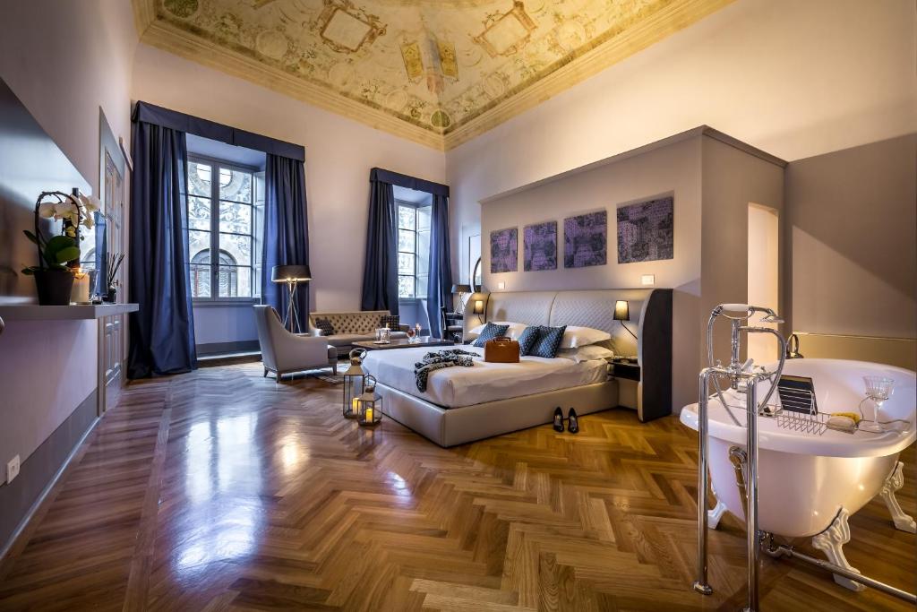 1 dormitorio con cama, bañera y lavamanos en Palazzo Ridolfi - Residenza d'Epoca, en Florencia