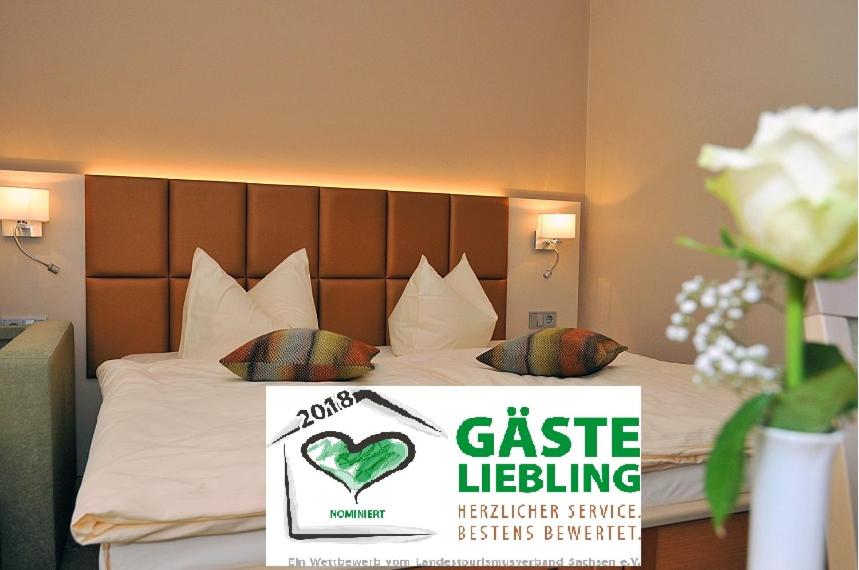 una habitación de hotel con una cama con un cartel. en Hotel Friesen en Werdau