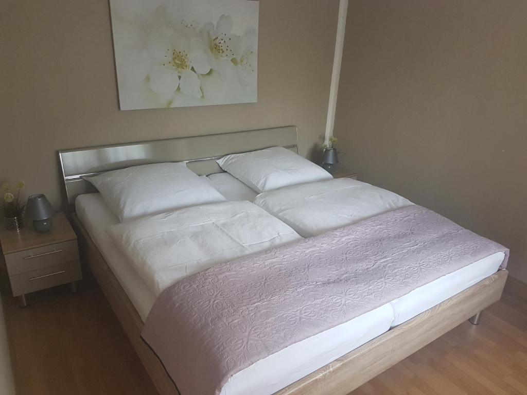een bed met witte lakens en kussens in een slaapkamer bij Ferienhaus Richter in Bad Schandau