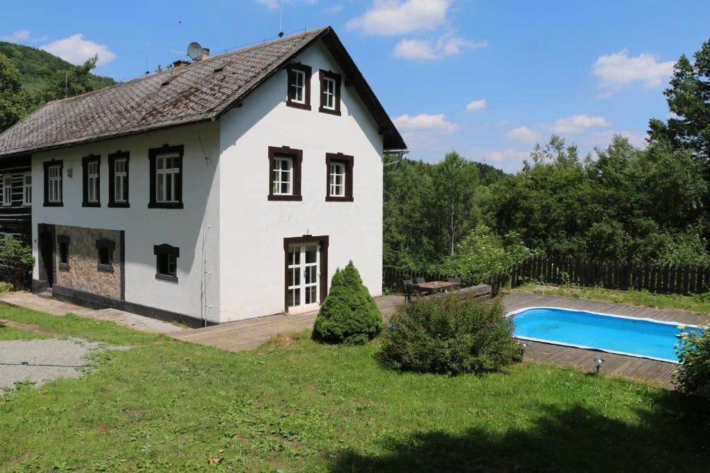uma casa branca com uma piscina em frente em Roubenka nad řekou em Noviny pod Ralskem