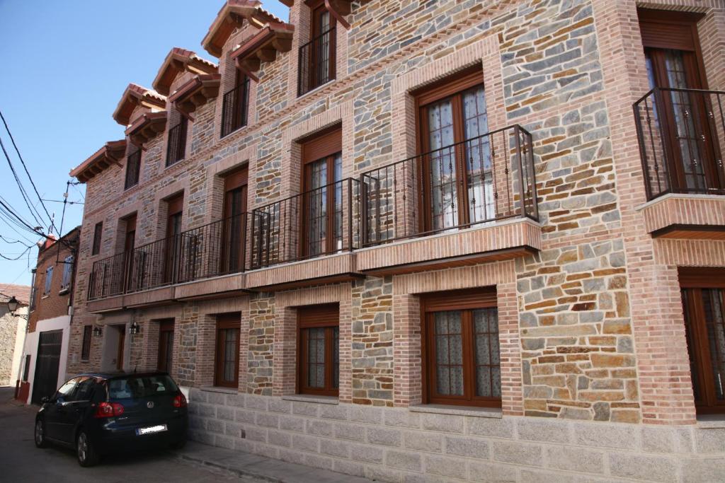 um carro estacionado em frente a um edifício de tijolos em Casa Rural La Fragua em Guadalix de la Sierra