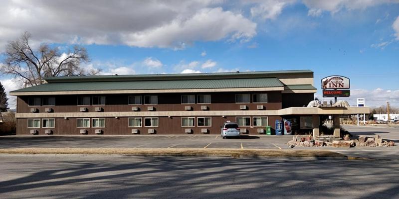 un gran edificio con un cartel en un estacionamiento en Buffalo Bill's Antlers Inn, en Cody