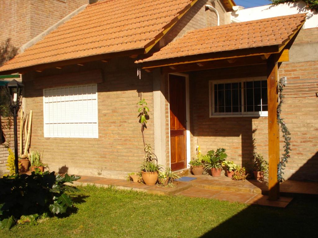 una casa de ladrillo con un porche con macetas en Departamento carlos paz en Villa Carlos Paz
