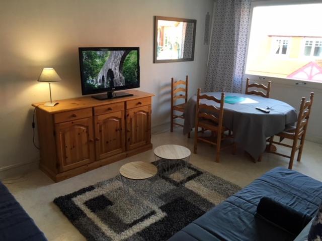 Il comprend un salon avec une télévision et une table à manger. dans l'établissement Plein Ciel Appartement, à Le Touquet-Paris-Plage