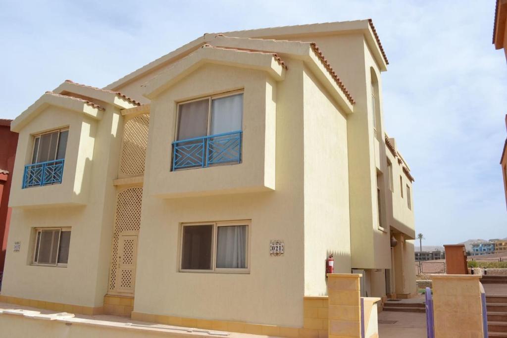a house with blue windows on the side of it at Standalone Villa with Garden in Porto Sokhna in Ain Sokhna