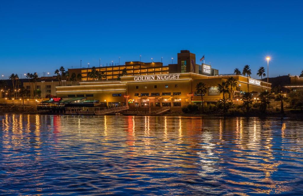 a building next to a body of water at night at Golden Nugget Laughlin in Laughlin