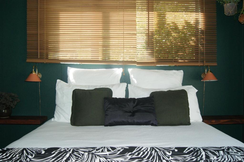 a large bed with white pillows and a window at Waitapu Springs B&B in Takaka