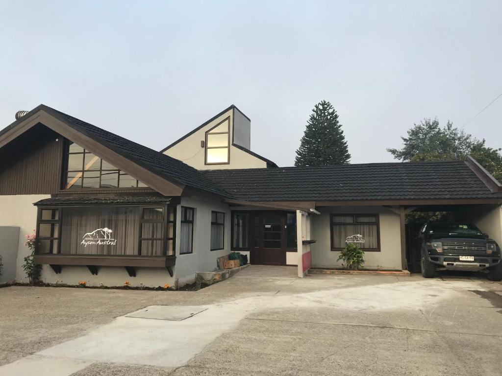 una casa con un coche aparcado delante de ella en Hotel Aysen Austral, en Puerto Aysén