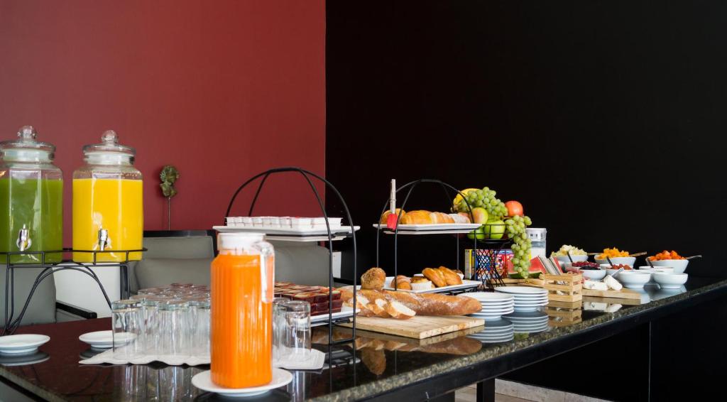 A buffet counter stocked with juices, fruit, pastries and cold dishes.