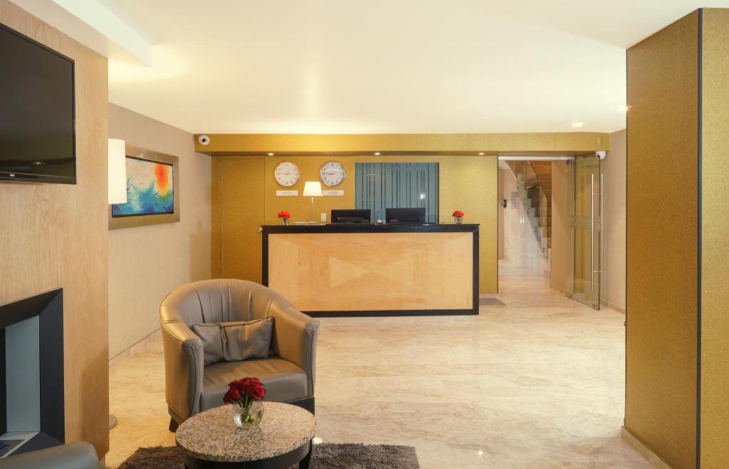 The reception lobby, with a compact front desk, elevator area and lounge chair.