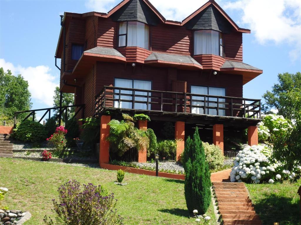 a large house with a garden in front of it at Boomerang Inn in Pucón