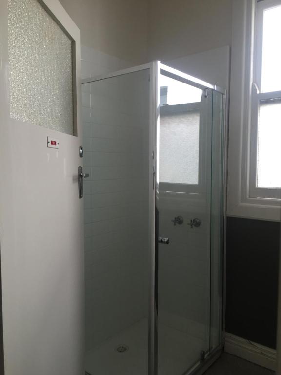 Western Hotel Ballarat في بالارات: دش مع باب زجاجي في الحمام