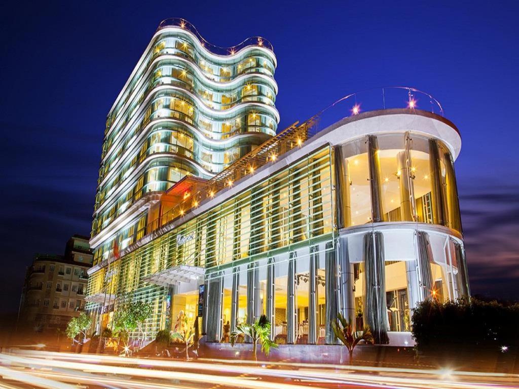 a large building at night with traffic in front of it at River Hotel in Hà Tiên