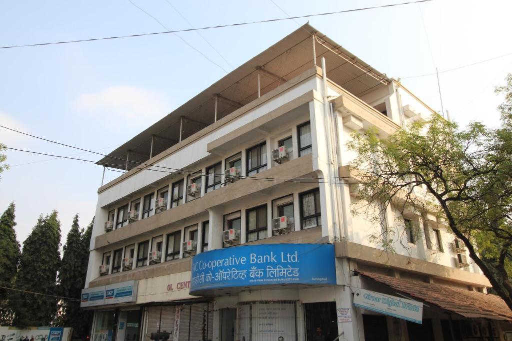 un edificio con una señal azul delante de él en Hotel Girnar, en Aurangabad