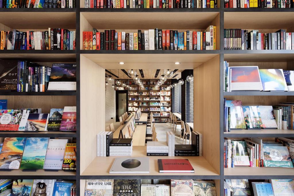 eine Bibliothek mit vielen Bücherregalen in der Unterkunft LAMP LIGHT BOOKS HOTEL nagoya in Nagoya