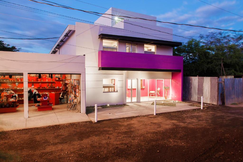 een huis met een paarse gevel en een garage bij Airport Inn Managua in Managua