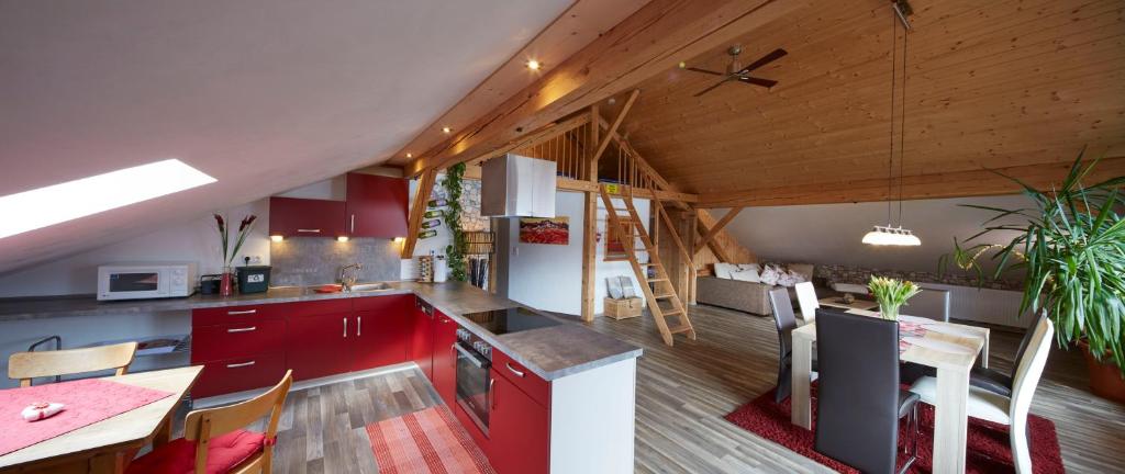 eine Küche mit roten Schränken und einem Tisch im Zimmer in der Unterkunft Haus Sonnblick in Wängle