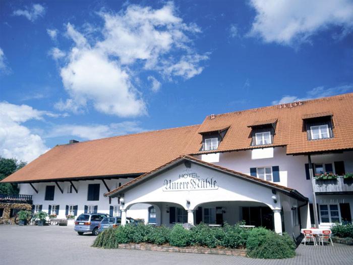 a large white building with a brown roof at Hotel "Untere Mühle" in Schwabmühlhausen