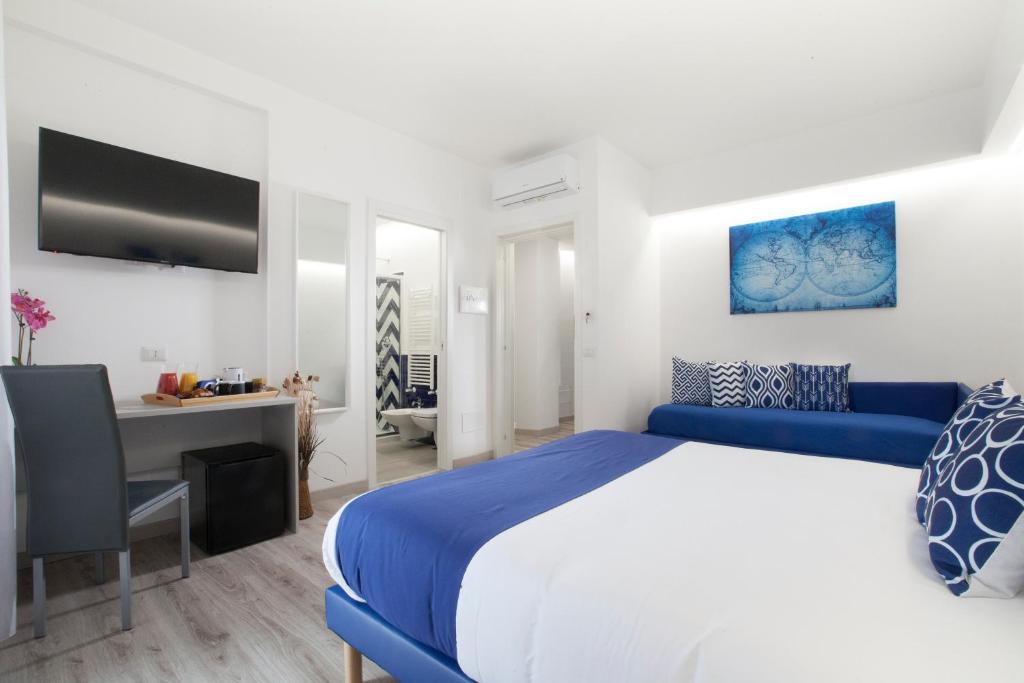 Un dormitorio con una cama azul y blanca y un escritorio en Sirocco Suites, en Sant'Agnello