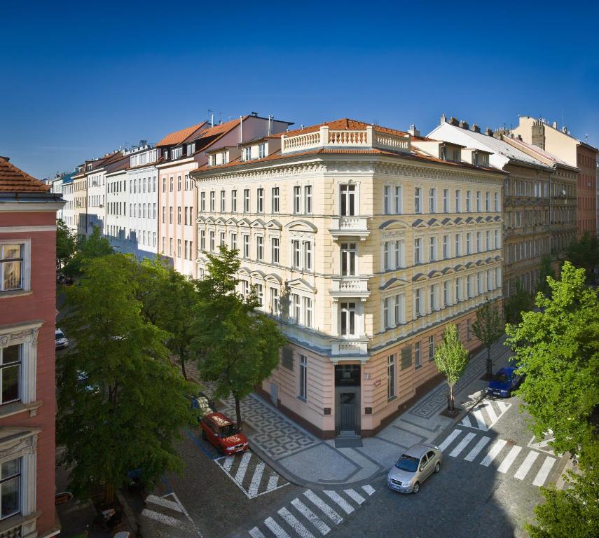 een groot gebouw met auto's geparkeerd voor het bij Mamaison Residence Belgická Prague in Praag