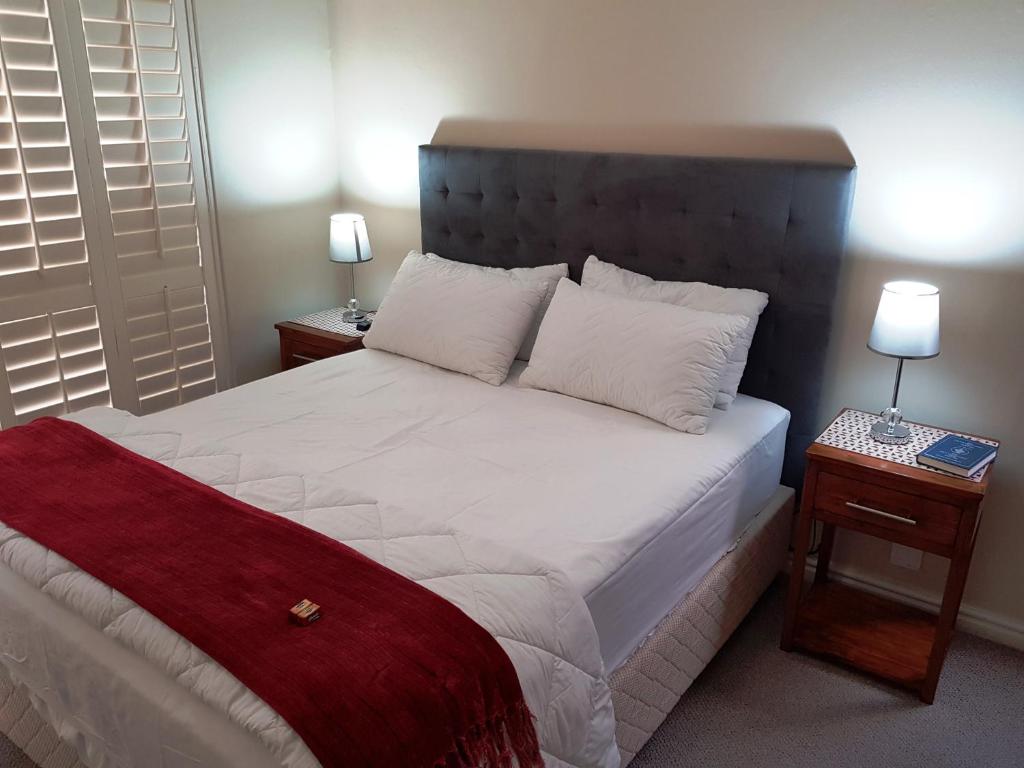 a bedroom with a large white bed with two tables at Break-A-Way in Langebaanweg