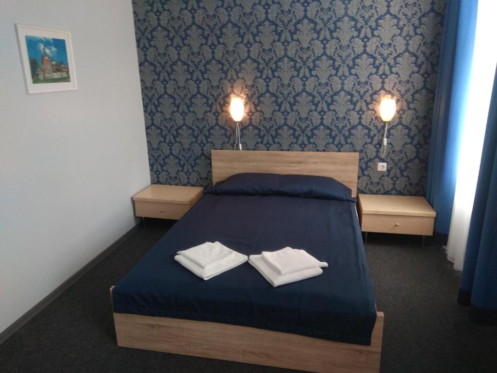 ein Schlafzimmer mit einem Bett mit zwei Handtüchern darauf in der Unterkunft Alex Hotel in Kohtla-Järve