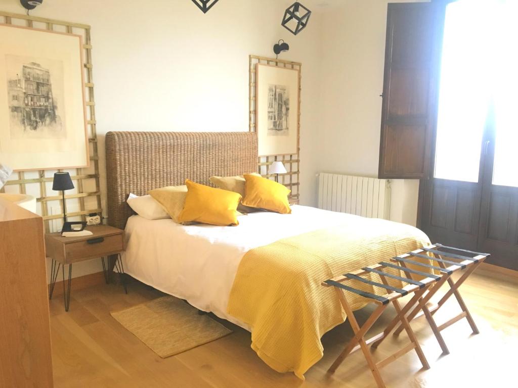 ein Schlafzimmer mit einem Bett mit gelben Kissen in der Unterkunft Luz del Huécar in Cuenca