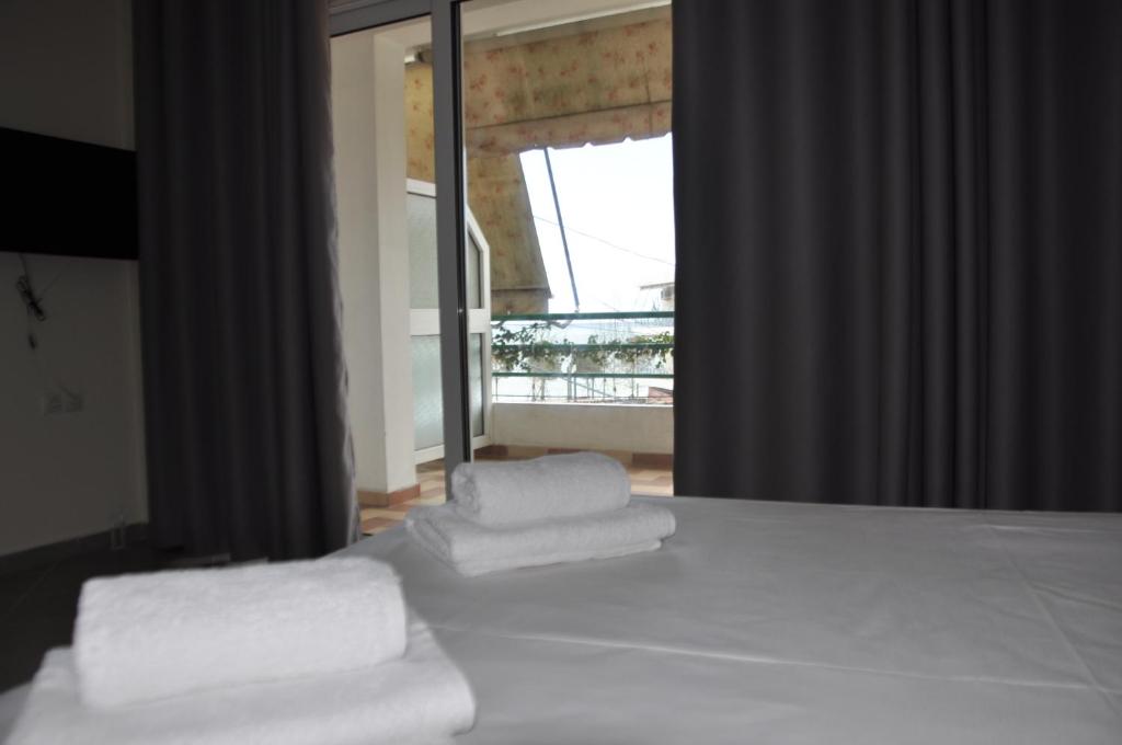Un dormitorio con dos toallas en una cama con ventana. en Zotos Apartment, en Himare