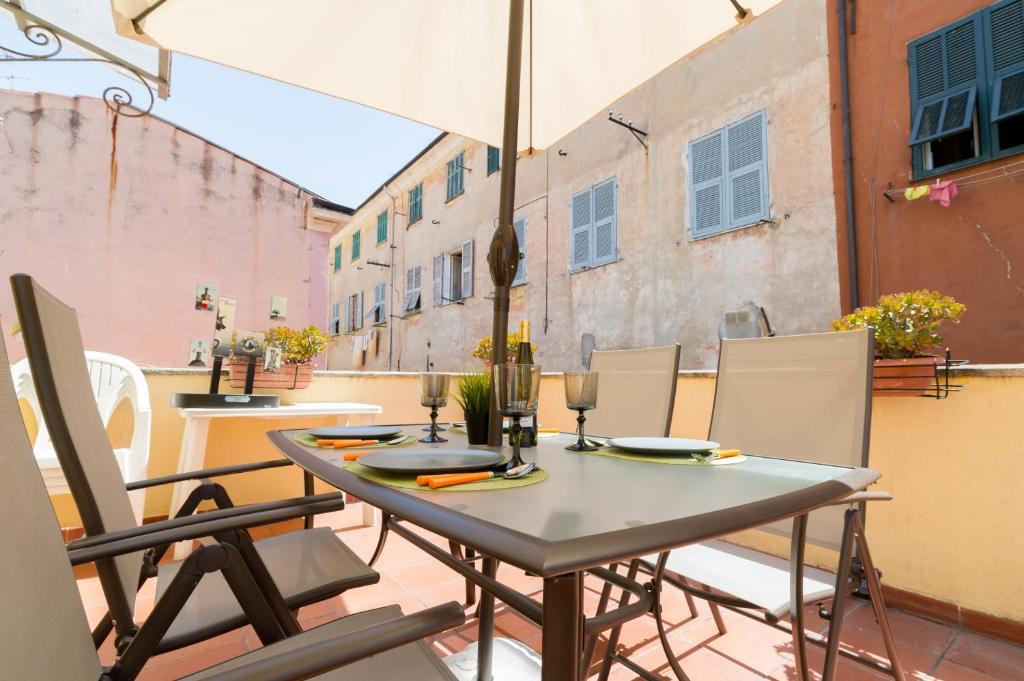 een tafel met stoelen en een parasol op een balkon bij Apartment In The Heart Of Sanremo in Sanremo