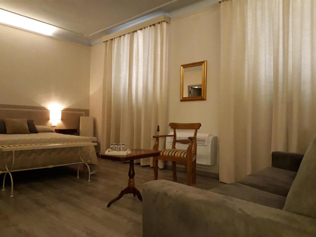 een woonkamer met een bed en een bank bij Le Camere di Caterina in Lucca