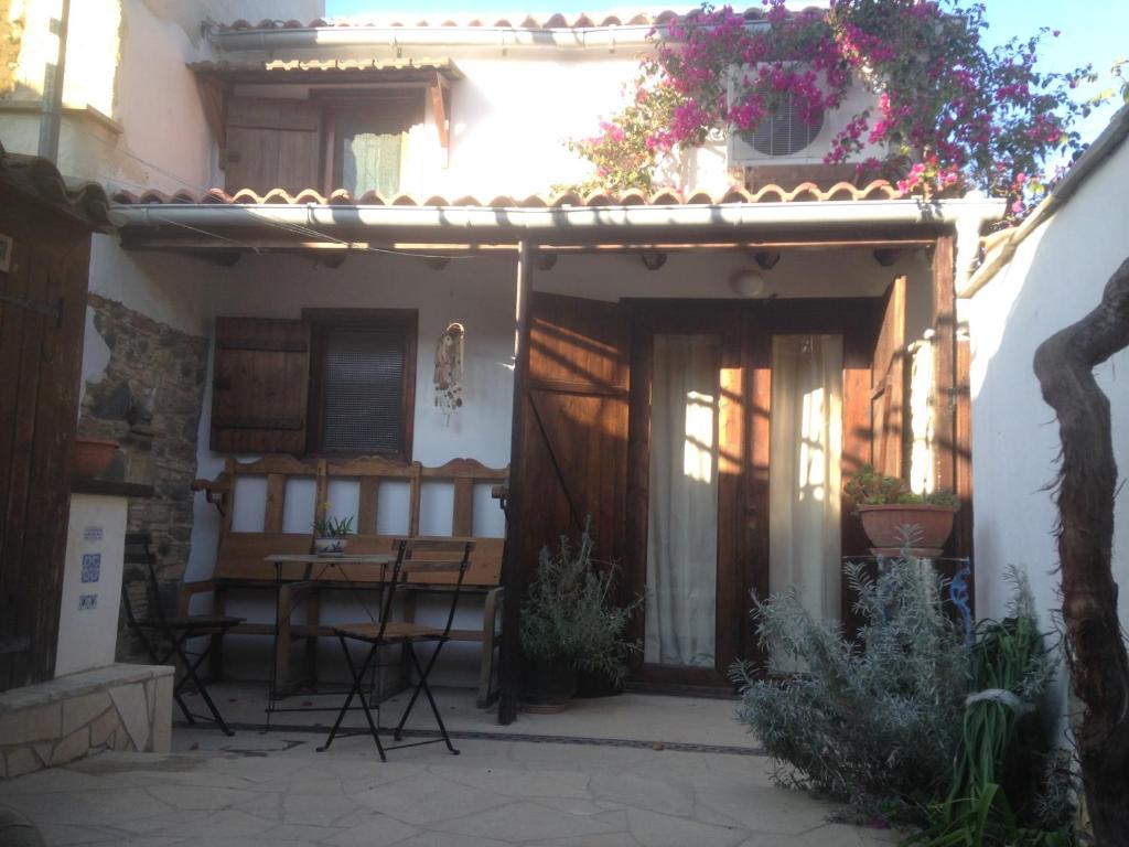 een huis met een patio met een tafel en stoelen bij Guesthouse Gonia in Pera Orinis