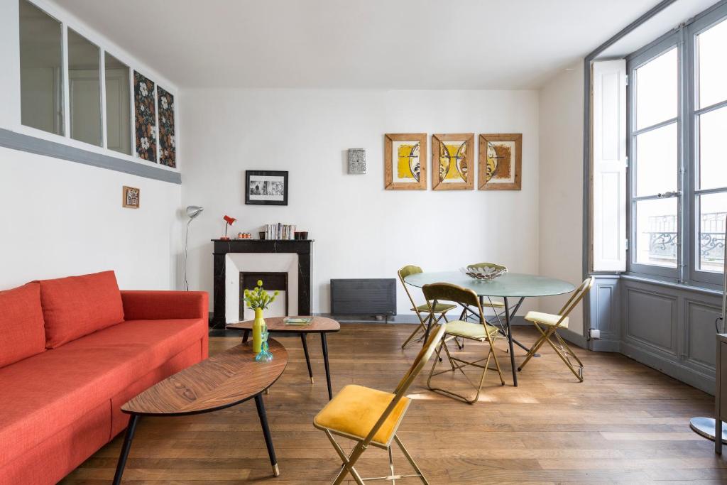 sala de estar con sofá rojo y mesa en L'Atelier Nantais by Cocoonr en Nantes