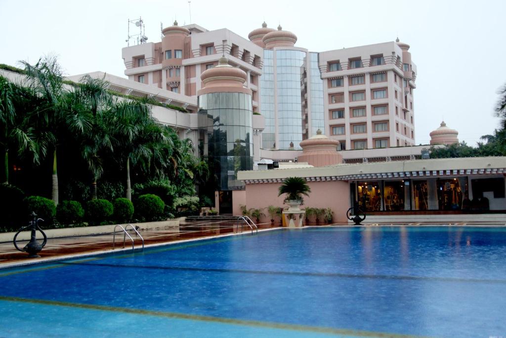 a large swimming pool in front of a building at Hotel Swosti Premium Bhubaneswar in Bhubaneshwar