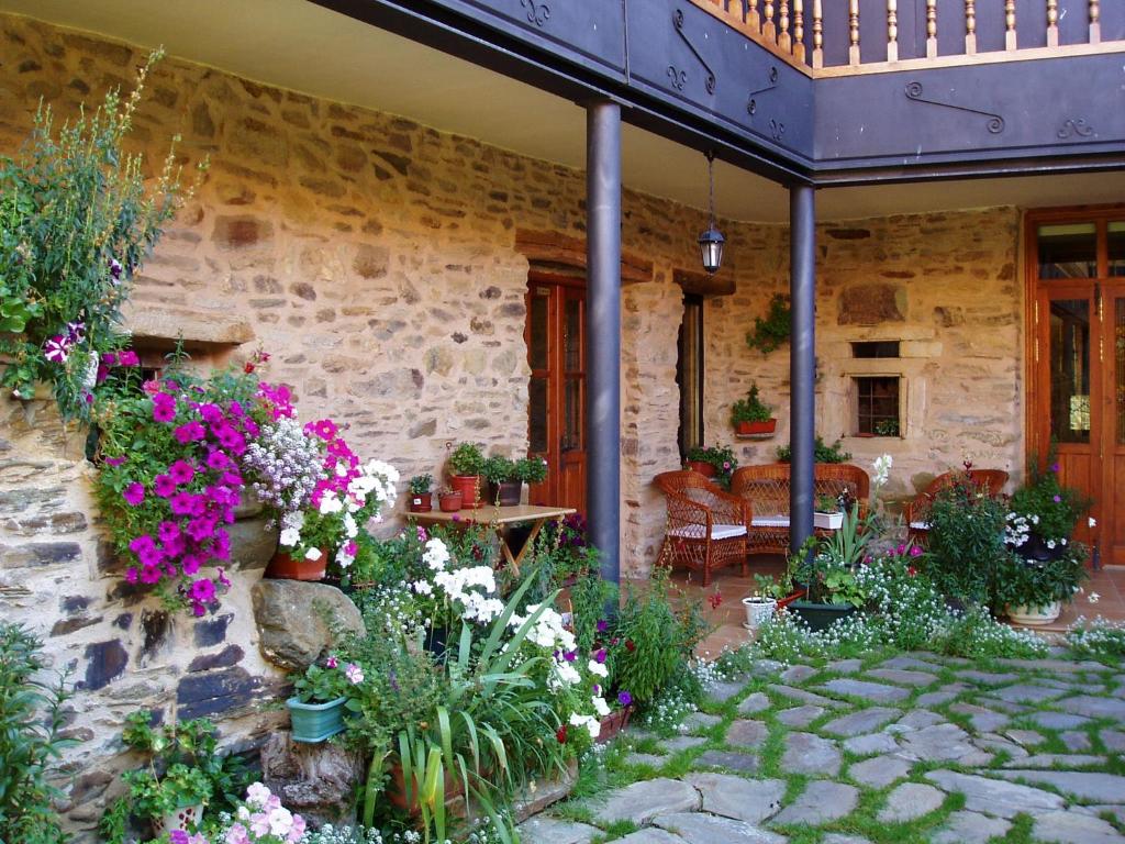 una casa con flores a un lado. en La Casa del Filandón- HOTEL RURAL, en Quintanilla de Somoza