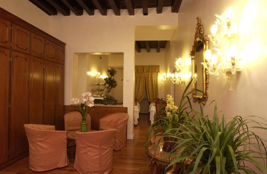 a salon with a waiting room with chairs and flowers at Hotel Locanda Canal in Venice