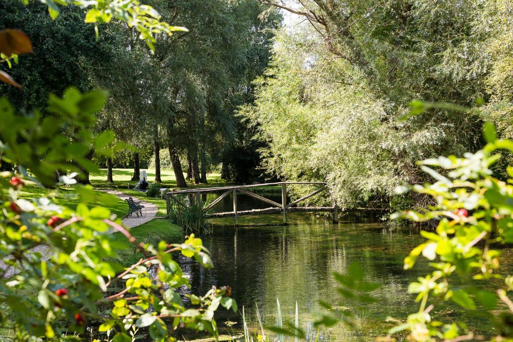 uma ponte sobre um rio num parque em Hornsbury Mill em Chard