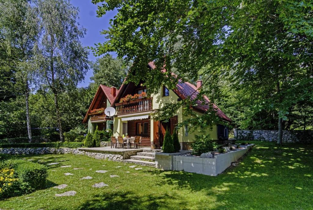 une maison dans une cour avec une pelouse dans l'établissement Chalets Bogo & Neno, à Ledenice