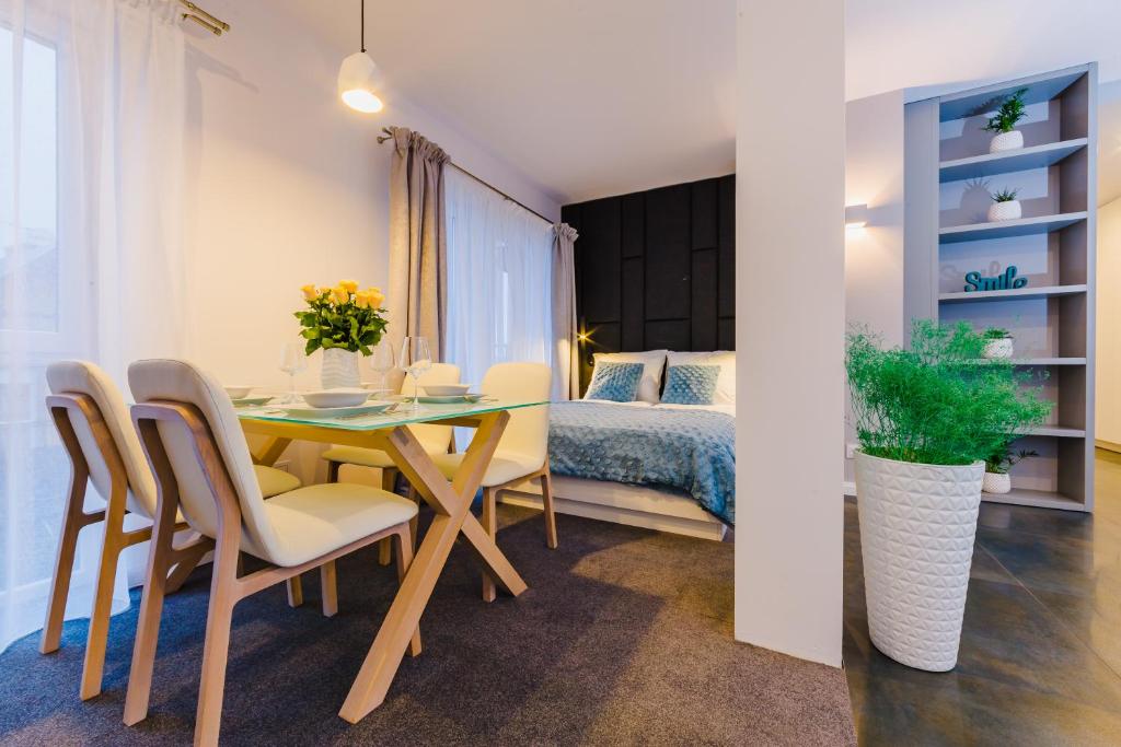 jadalnia ze stołem, krzesłami i łóżkiem w obiekcie Zigzak Apartments Superior 9A w mieście Rzeszów