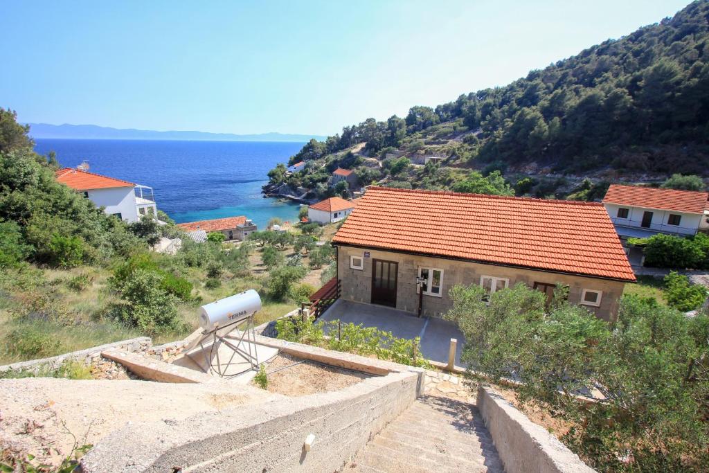 a house on a hill with the ocean in the background at Robinson Torac in Gdinj