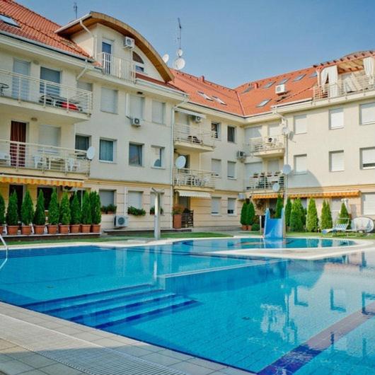 a large swimming pool in front of a building at Relax Beach Apartman in Hajdúszoboszló