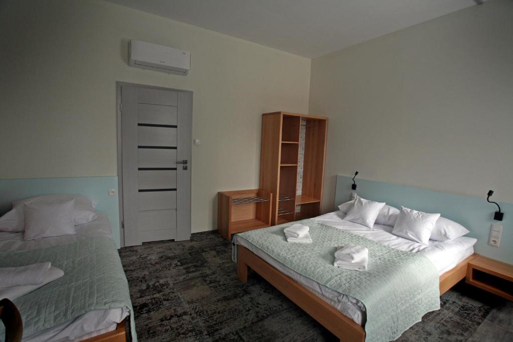 a bedroom with two beds with towels on them at Motelik Grosar Gorlice in Gorlice