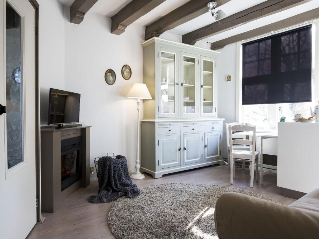 a living room with a white cabinet and a television at Boutique Holiday Home in Middelburg with Roof Terrace in Middelburg