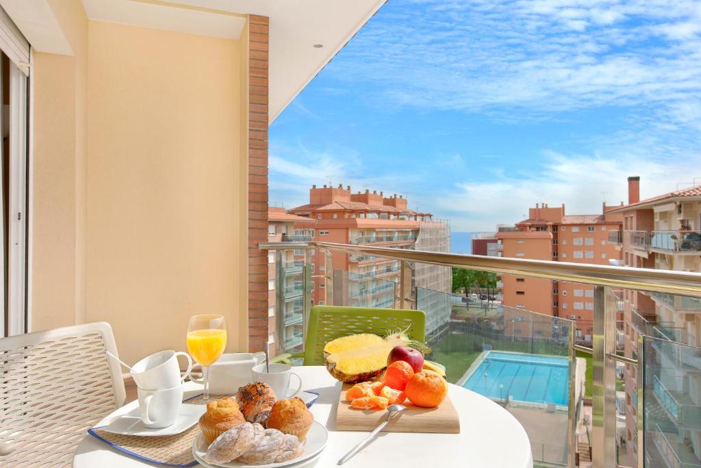 a table with breakfast food on a balcony with a view at Europa Square Apartment in Santa Susanna